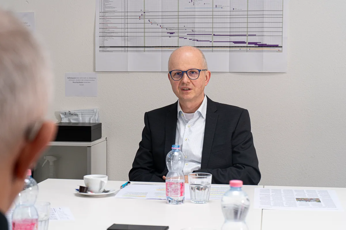 Ein älterer Mann sitzt an einem Tisch.